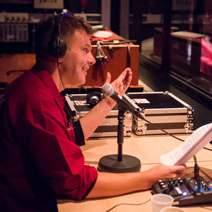 Dave van der Wal achter de microfoon met koptelefoon op.